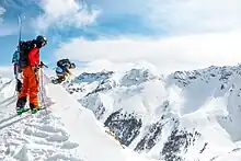 skiers standing on top of mountain