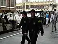 Two policemen (old patrol uniform) patrol Kraków's Old Market Square