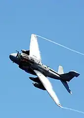 An EA-6 Prowler with condensation in the cores of its wingtip vortices and also on the top of its wings.