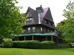 A stone mansion surrounded by grass and bushes