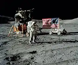 The first image is a successful moon landing in full color containing the American flag, an astronaut, a lunar rover, and a lunar landing module. The second image is an emblem containing a statue of the Greek god Apollo, red stripes inside an eagle made of white lines, the Moon, Saturn, and a spiral galaxy; along the outside of the emblem are is the word "Apollo" along with the number "seventeen" in roman numerals, and then the name "Cernan," "Evans," and "Schmitt." The third and final image contains Schmitt on the left, Cernan in the middle and sitting, and Evans behind Cernan.