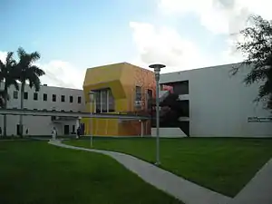 A gray building with a bright yellow entrance