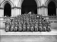 Group portrait of the first 69 nurses and 11 staff to leave for World War I. Taken on the steps of the General Assembly Library, Wellington, by an unidentified photographer for The Press newspaper of Christchurch.