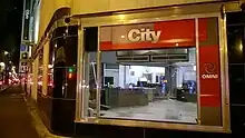 A studio partially disassembled, seen through the large picture window on the corner of the Hudson's Bay Building. City and Omni signage is seen near the window.