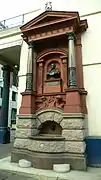 elaborate drinking fountain on the side of a large urban building