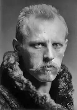 Head and shoulders portrait of Fridtjof Nansen, facing half-right. He has close-cropped hair, a wide, fair moustache and is wearing a heavy fur coat.