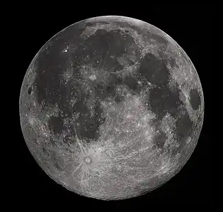 Full Moon in the darkness of the night sky. It is patterned with a mix of light-tone regions and darker, irregular blotches, and scattered with varied circles surrounded by out-thrown rays of bright ejecta: impact craters.