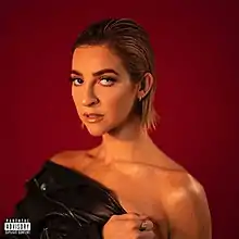 Gabbie Hanna facing towards the camera with a red background.