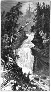 A black and white artistic work of a large waterfall dropping over a rocky cliff on a forested mountain. The falls are surrounded by large conifer trees and a fisherman is in the foreground.