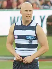 Baldheaded male athlete during an Australian rules football game