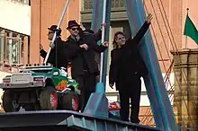 Several men standing on a parade float while waving