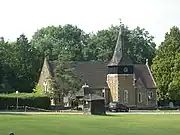 A distant view of the church across the green, of which Ian Nairn approved