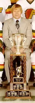  Gregg Pilling sitting behind the Lockhart Cup in a team photo of the 1976-77 Philadelphia Firebirds