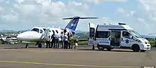 A patient is transferred between an aircraft and an ambulance at Le François airport.