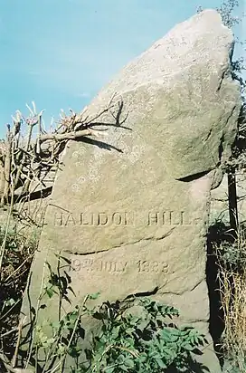 A large, rough-hewn stone with engraving on it