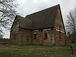 Brick building with steep roof and Gothic windows