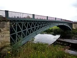 A single-span metal bridge over a river