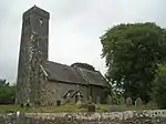 A simple church seen from the southeast with a tall slender tower on the left, then the nave and a chancel with a slightly higher roof line