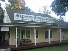 Yellow, house-like barn with a large white museum sign