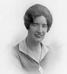 sepia-toned photograph of the head and shoulders of a smiling white woman