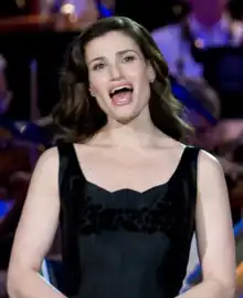 A dark-haired Idina Menzel, singing at an event