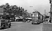 Photograph of a street with trolleybuses and a police box on the pavement