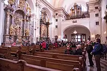 Pilgrims inside the church looking to the altar of the Infant Jesus of Prague