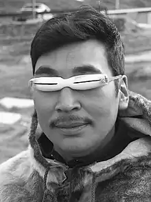 An Inuk man wearing snow goggles