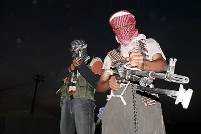 Two masked Iraqi men with weapons during the insurgency that followed the 2003 invasion of Iraq