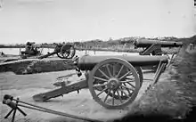 Two Model 1829 32-pounder siege and garrison guns, rifled by the James method (64-pdr James rifles). The one in the foreground is on a siege carriage. The one behind is on an iron, front pintle, barbette carriage.