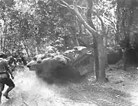 Japanese tanks and infantry advance through the Bataan jungle.