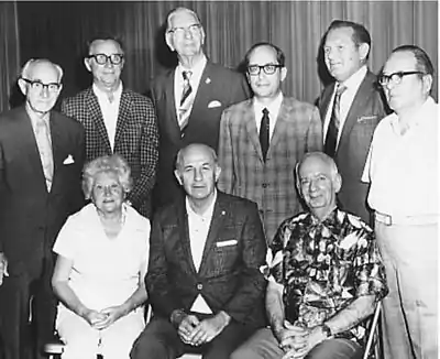 Benjamin Wishnietsky, standing third from the right at the Hollywood (Florida) Stamp Club. Bottom row, left to right: Edith York, Uhle York, John J. Britt. Top row, left to right: Irwin Brown, Tom Bojanowski, unknown person, Benjamin Wishnietsky, Jerry Kedrierski, unknown person. (Florida). (c. 1975)