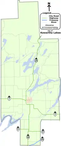 "A map of the entire City of Kawartha Lakes, outlined by a grey line. The lakes, rivers, and roads of the region are shown. Lakes and rivers are dotted across the region and represented by blue shapes and lines. Kawartha Lakes is shaped like a cross which has been stretched vertically, and is approximately one quarter as wide as it is tall. For identification purposes, the remaining items are described in reference to the horizontal and vertical bar of the cross. Provincial highways, labelled, cross the map in several locations: Highway 35 bisects the entire map, travelling vertically from the bottom-centre to the upper-right along the vertical bar. Highway 7 crosses horizontally just below the mid-point from the left; After crossing Highway 35, it proceeds at an angle to the bottom right corner of the horizontal bar. Highway 7A is a straight and horizontal, bisecting the map below the horizontal arm of the cross. Highway 115, shown as two lines as it is a divided freeway, occupies a small space near the bottom-right corner of the vertical bar, crossing it at a forty-five degree angle up and to the right. The remaining black lines represent the numbered city roads."