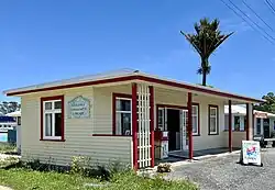 wooden library building with nikau palm behind