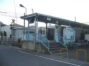 Entrance to Koginosato station. A train can be seen waiting at the platform.