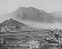 General view of Kowloon c. 1868, with Lion Rock in the background overlooking the Qing-era Kowloon Walled City