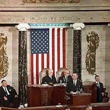 Political leaders in US with flag in background.