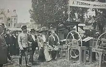 The Duke and Duchess of Saxe-Coburg and Gotha walking towards an outdoor display of agricultural equipment