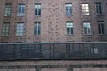 A light court in the center of the Barbizon's Lexington Avenue facade, above the second floor. There is a black fence in front of the light court.