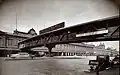 Cortlandt Street Ferry Depot is visible underneath a pedestrian overpass at Liberty Street Ferry Terminal, 1938