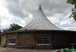 round brick building with a tent-like roof