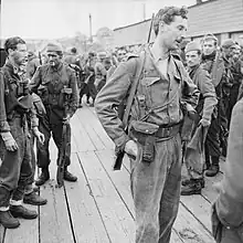 Exhausted British soldiers standing on a quayside