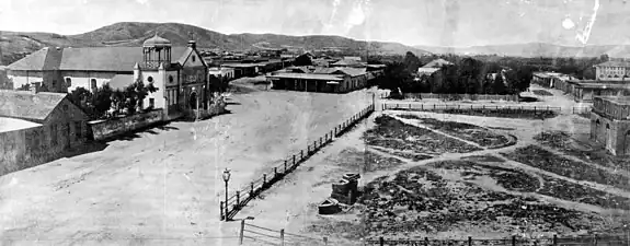 The "Old Plaza Church" facing the Plaza, 1869. The brick reservoir in the middle of the Plaza was the original terminus of the Zanja Madre.