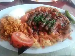 Kebab served over pide with pilav