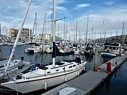 A north-to-east view from a boat slip in Marina del Rey's Basin E; Marina City Club is the left-most building, with the Ritz-Carlton Marina del Rey second from left. This photo depicts the original wood and canvas docks at Wayfarer Marina, replaced in 2019 by new concrete docks.