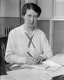 A portrait of Mary van Kleeck as a young woman sitting at a desk of papers