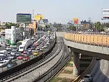 An image of the track system for Oceanía, where the Line 5 rails are located at grade, while Line B's are in an elevated viaduct.