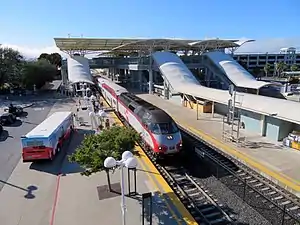 A railway station with multiple platforms and a large canopy structure