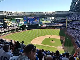 A green baseball field set inside a metal stadium