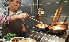 Mixian (米线) rice noodles being cooked in copper pots (铜锅),  China